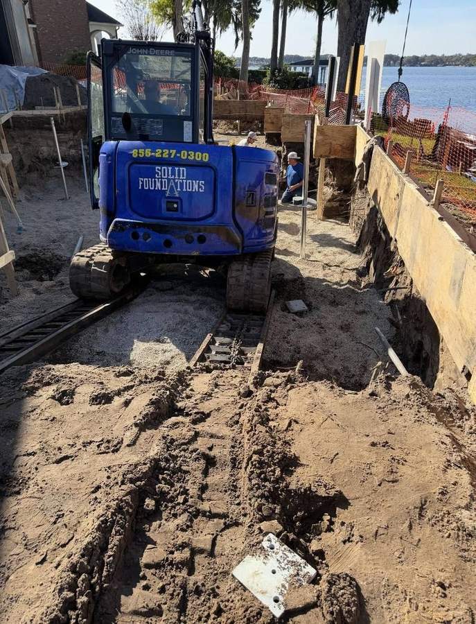 Shoreline erosion repair — Solid Foundations excavator stabilizing a bank
