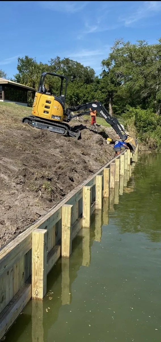 Finished wood bulkhead holding back a sloped waterfront yard