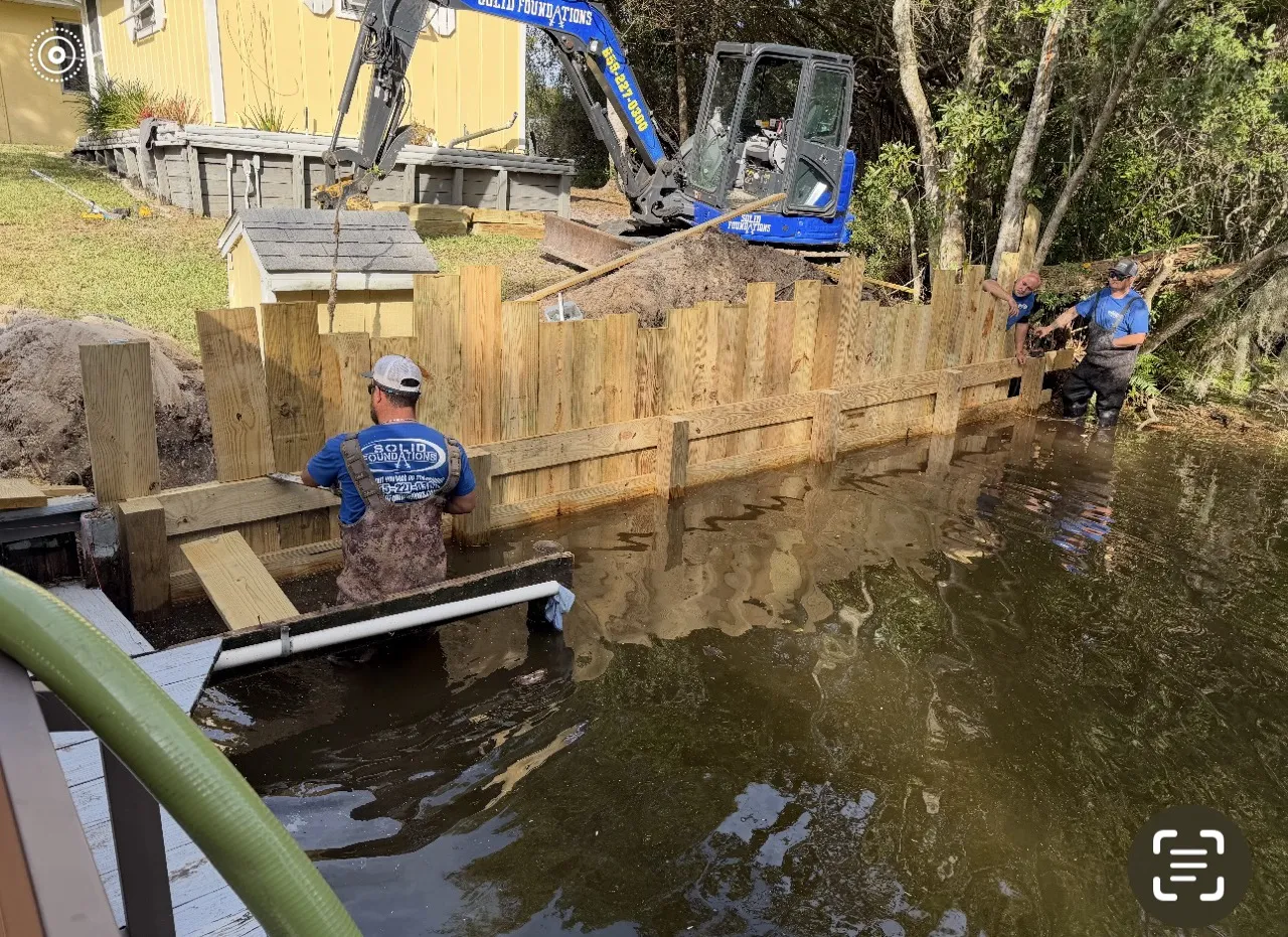Solid Foundations crew setting new bulkhead boards while standing in the water